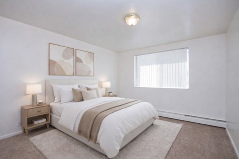 A bedroom with a large bed and two lamps on the side table.