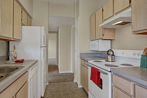 A kitchen with a white refrigerator and a white stove top oven.