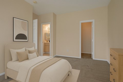 A bedroom with a bed, dresser and mirror.