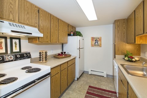 A kitchen with a white stove and wooden cabinets.