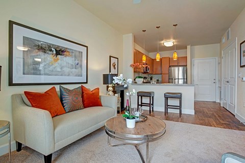 A living room with a couch, coffee table, and a painting on the wall.