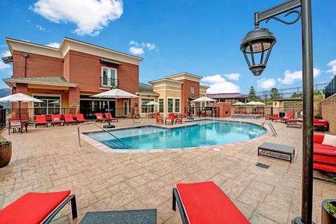 A pool area with a red bench and a lamp post.