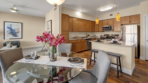 A modern kitchen with a dining table set for two.