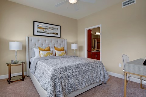 A bedroom with a large bed and a ceiling fan.