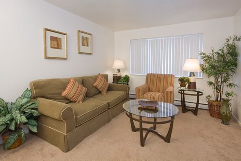 A living room with a couch, chair, and two lamps.