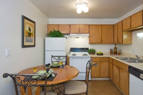 A kitchen with a table set for two.