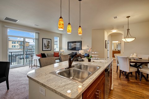 A kitchen with a sink and a dining table.
