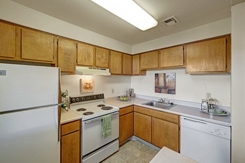 A kitchen with wooden cabinets and white appliances.