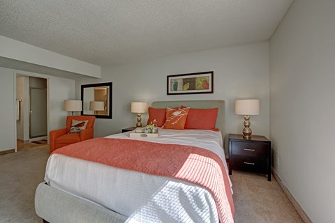 A bedroom with two beds and a chair.