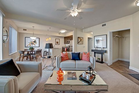 A living room with a white couch and a glass coffee table.