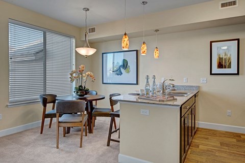 A kitchen with a table and chairs and a painting hanging on the wall.