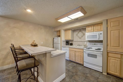 A kitchen with a table and chairs in it.