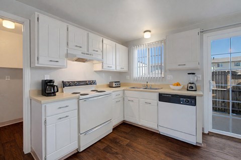 A kitchen with white cabinets and appliances.