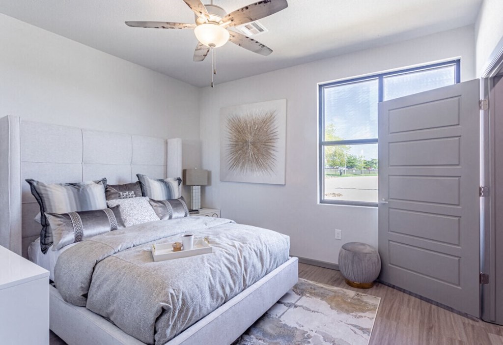 a bedroom with a bed and a ceiling fan