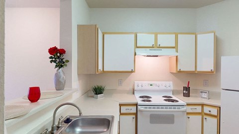 a kitchen with white appliances and white cabinets and a sink
