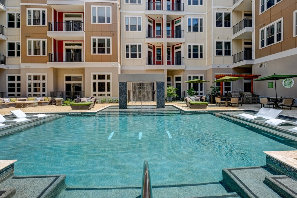 a large swimming pool in front of an apartment building
