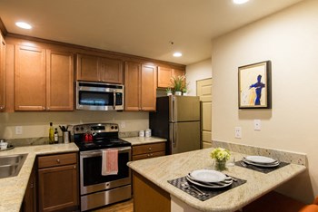 Stainless steel appliances, lots of counter space and cabinet storage, and a dining area. Windsong Apartment Kitchen in Issaquah Washingto - Photo Gallery 3