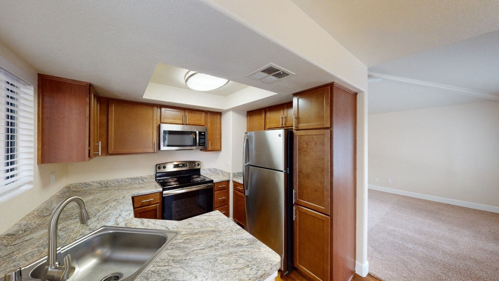 a kitchen with granite countertops and stainless steel appliances