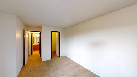 A hallway with a carpeted floor and two doors.