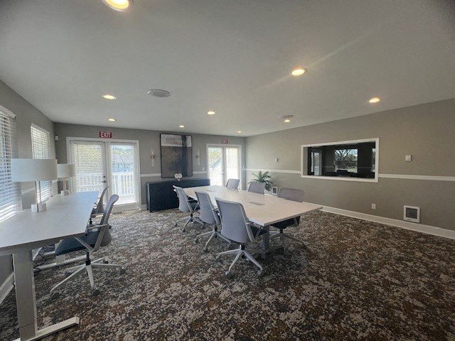 a conference room with a table and chairs and a television