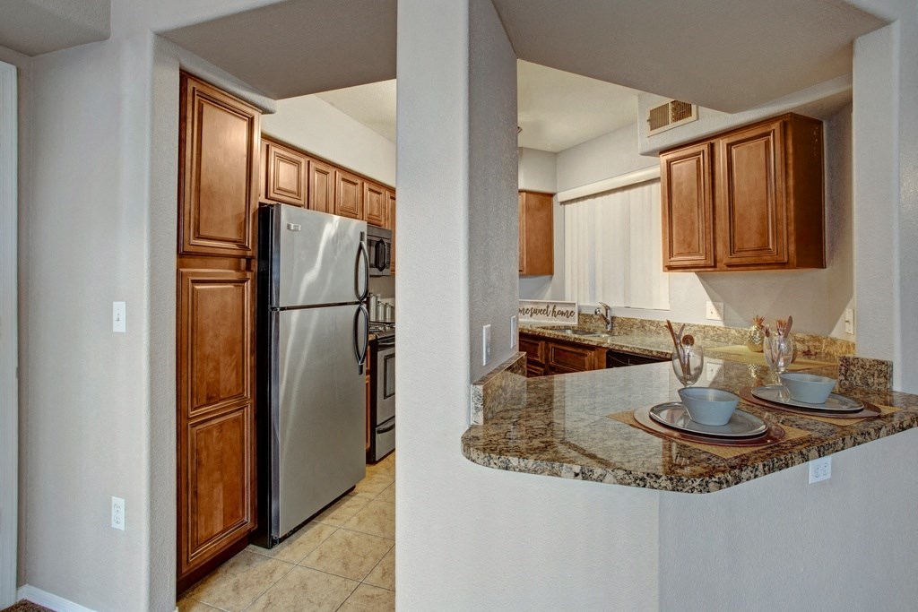 a kitchen with wooden cabinets and granite countertops