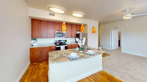 A kitchen with wooden cabinets and a marble island.