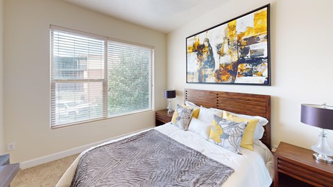 A bedroom with a large bed and a painting on the wall.