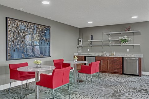 A modern lounge with a large painting on the wall and a patterned floor.