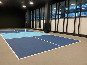 a tennis court in a building with windows