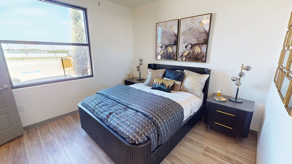 A bedroom with a large bed and a window overlooking a parking lot.