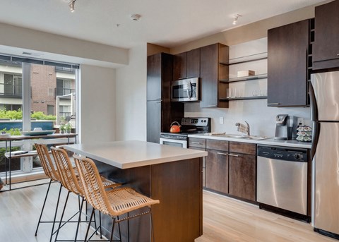 A modern kitchen with wooden cabinets and stainless steel appliances.