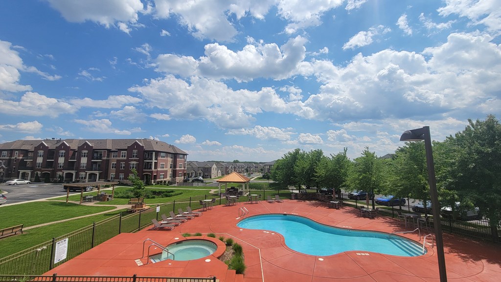 a view of a swimming pool and a resort with a building in the background