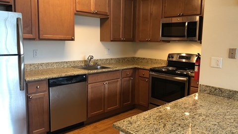 A kitchen with granite countertops and stainless steel appliances.