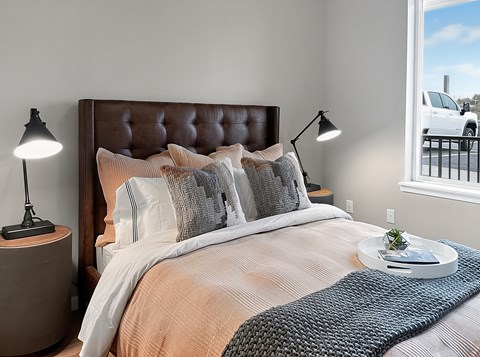 A bedroom with a large bed and a window overlooking a parking lot.