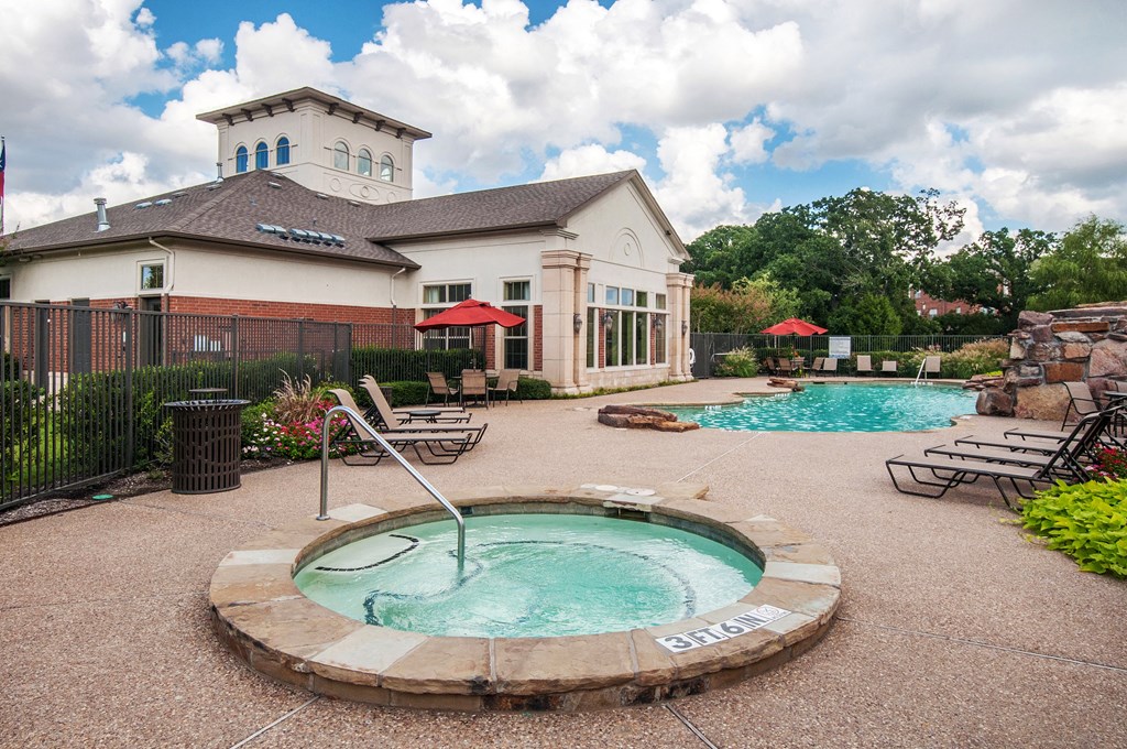 a pool with a hot tub in front of a house