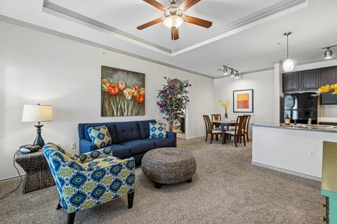 A living room with a blue couch and a ceiling fan.