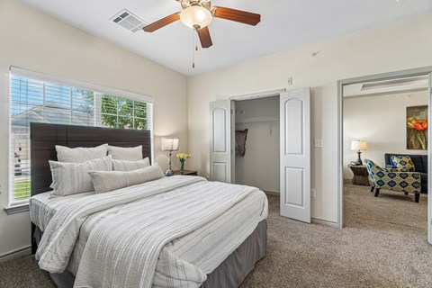 A bedroom with a large bed and a ceiling fan.