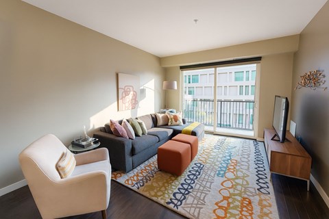A living room with a couch, chair, and television.