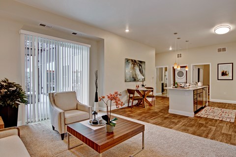 A living room with a white couch, a wooden coffee table, and a painting on the wall.