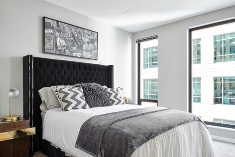 A bedroom with a large bed and a picture on the wall.
