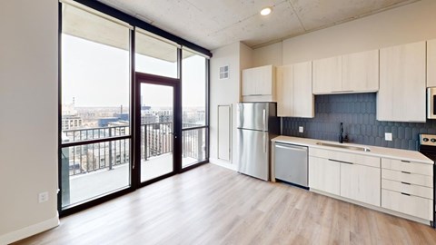 A kitchen with white cabinets and a stainless steel refrigerator.
