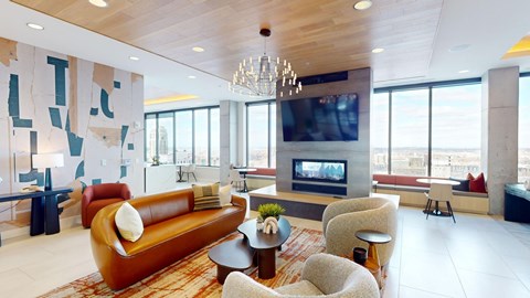A living room with a brown leather couch and a chandelier.