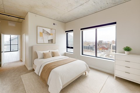 A bedroom with a large bed and a view of the city.