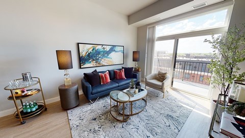 A living room with a blue sofa and a painting on the wall.