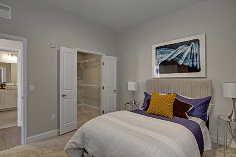 A bedroom with a large bed and a painting above it.