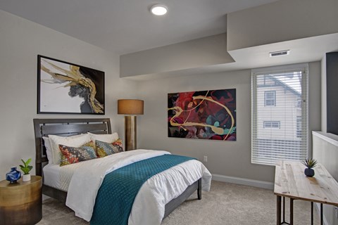 A bedroom with a large bed and a painting on the wall.