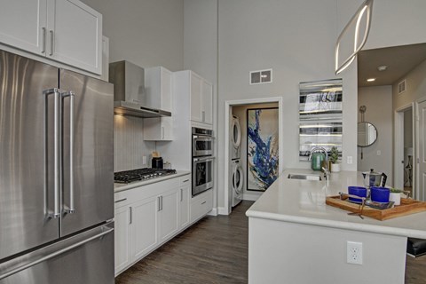 A modern kitchen with stainless steel appliances and white cabinets.