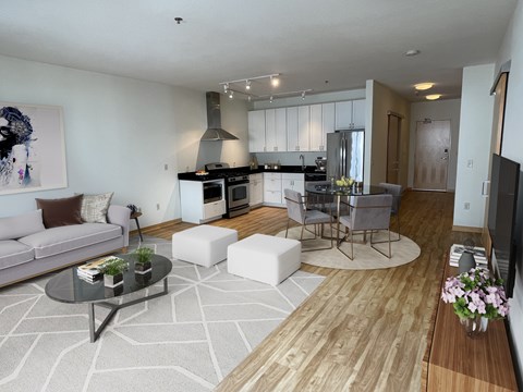 A modern living room with a grey sofa and a glass coffee table.