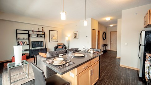 A modern kitchen with a dining table set for two.