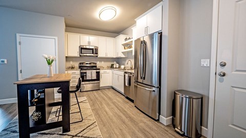 A kitchen with a refrigerator, microwave, and oven.